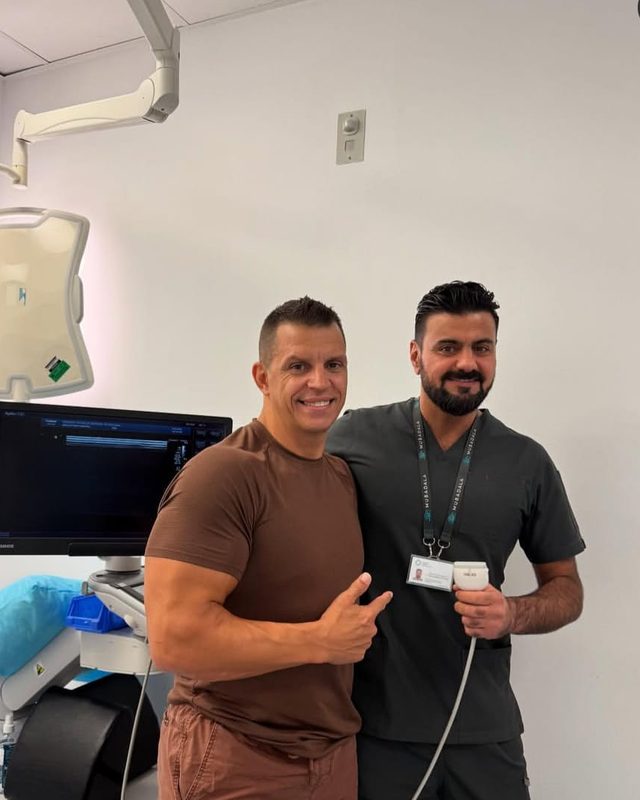 Dr. Shimas Salih with a patient in the clinic — a consultation in progress, with ultrasound equipment in the room